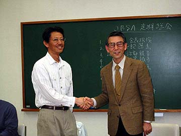 壇上で握手する二人の写真